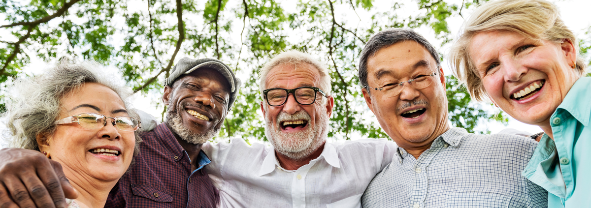 Diverse group of older adults with their arms around each other facing the camera.