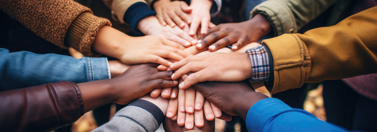 Image of multi-race hands touching in a circle.