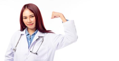 Young female doctor flexing her arms acting like a superhero.