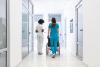 Wheelchair patient with professional African American female doctor and nurse specialist staff in corridor of hospital recovery center