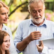 Clinician with family patients talking about medical consultation in a park