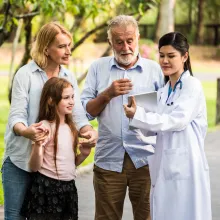 Doctor with family patients talking about medical consultation in a park. Healthcare concept