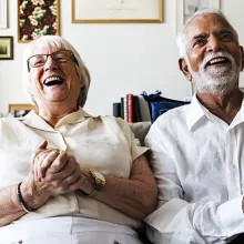 Group of elderly friends smiling on a sofa