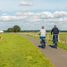 Two unidentified people cycle on a bike path