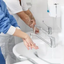 Doctors washing hands using disinfecting liquids in a surgical clinic.