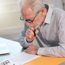 Elderly person with laptop sitting at a table