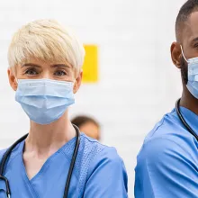 Female and male nurse standing next to each other with masks