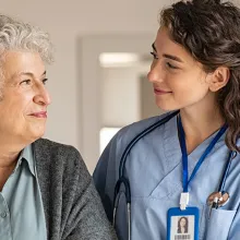 Female nurse walking next to elderly woman