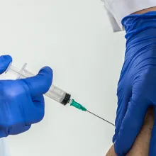 Clinician giving a senior woman a vaccination.