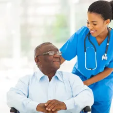 African nurse taking care of senior patient in wheelchair