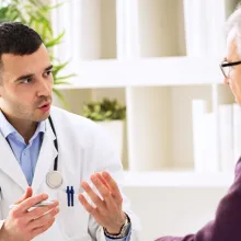 Clinician speaking with an older male patient.