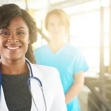 Two female and one male medical stuff standing and smiling 