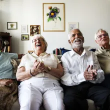 Group of senior friends sitting and watching tv together