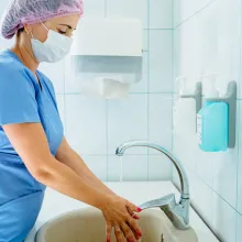 Image of healthcare worker washing hands in sink.