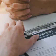 young male doctor or pharmacist writing prescription on clipboard