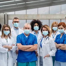 Group of doctors with face masks looking at camera.