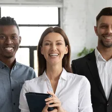 Corporate portrait successful smiling diverse employees team standing in office