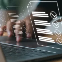 Image of a male hand at a laptop verifying a checklist on laptop screen.