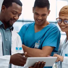 Both male and female healthcare staff looking at resource on a digital device.