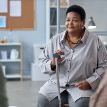 Portrait of senior black woman sitting in circle at mental health support group in retirement home