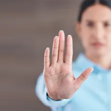 Woman holding up her hands making the stop/wait hand signal 