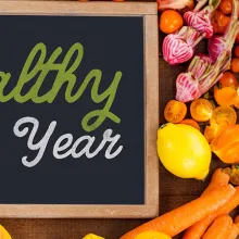 board surrounded by fruits and vegetables that says 'healthy new year'