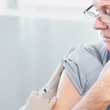 Female doctor administering male patient with COVID-19 vaccination