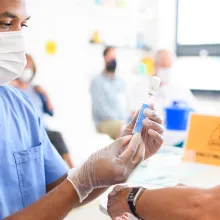 Medical professional administering vaccine to senior woman