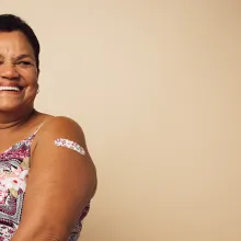 Person smiling with bandaid on arm