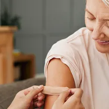 Person getting a bandaid put on by clinician