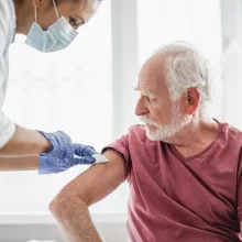 Senior man receiving vaccination from medical professional
