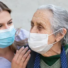 A medical professional holding the shoulders of a senior man