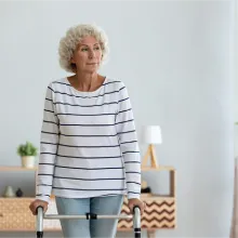 Senior woman in nursing home walking with a walker