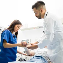 Doctor and nurse assessing a patient laying in hospital bed