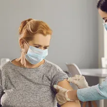 Clinician giving patient a vaccine in a nursing home setting