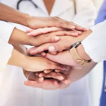 Image of clinicians hands in a huddle