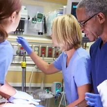 Clinicians surrounding patient on hospital bed