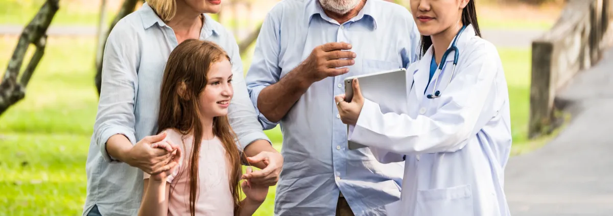 Doctor with family patients talking about medical consultation in a park. Healthcare concept