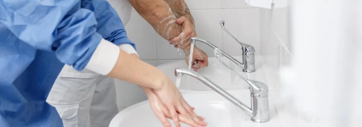 Doctors washing hands using disinfecting liquids in a surgical clinic.