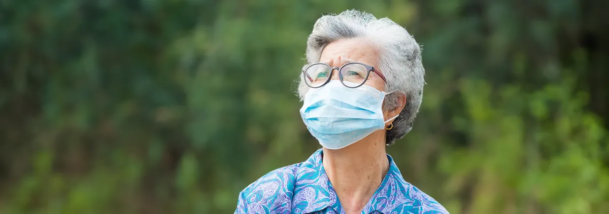 Portrait of elderly woman with short white hair, wearing face mask for health because have air pollution PM 2.5. Mask for protect virus, bacteria, pollen grains. Health care concept