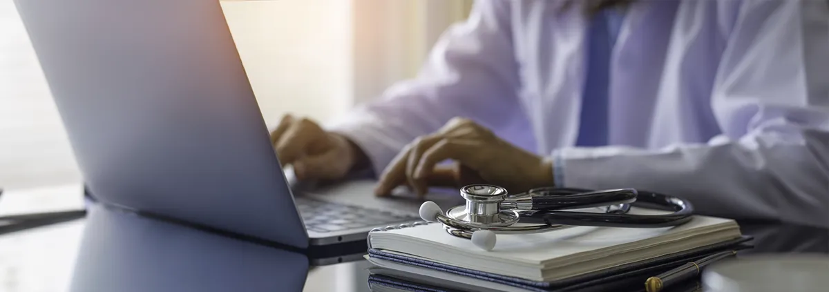 Stethoscope on prescription clipboard and Doctor working an Laptop on desk in hospital, Healthcare and medical concept, vintage color, selective focus.