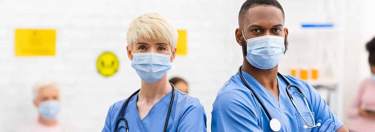 Female and male nurse standing next to each other with masks