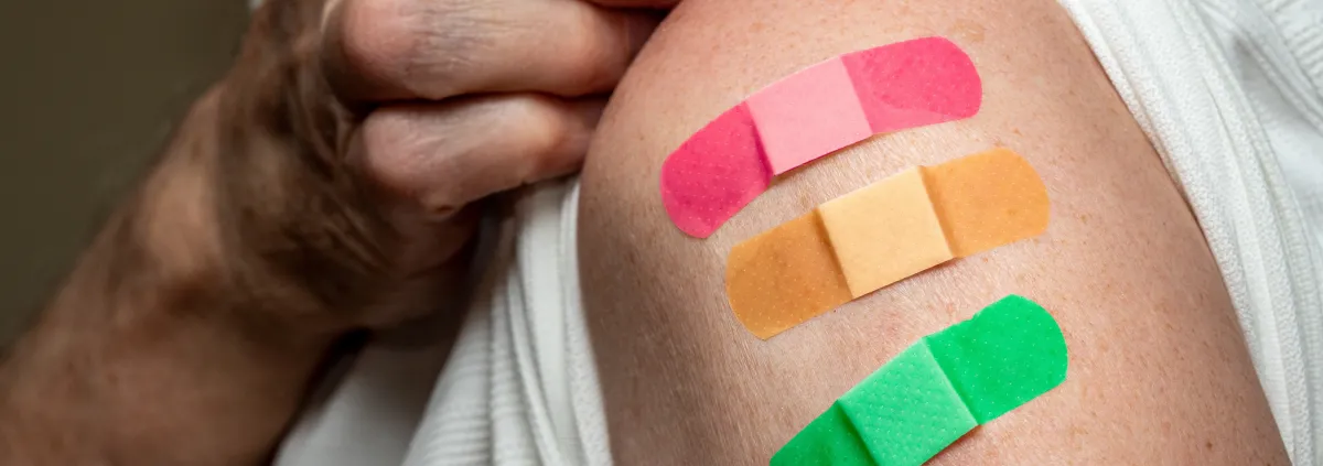 Senior caucasian man sleeve to show the third booster coronavirus vaccine shot in the shoulder.