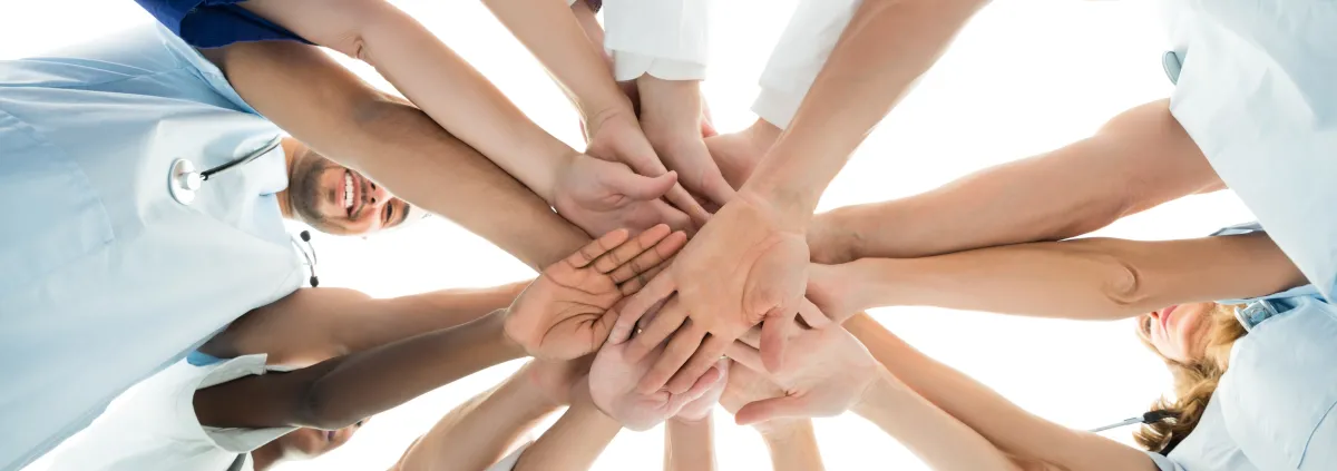 Directly below shot of multiethnic medical team stacking hands over white background