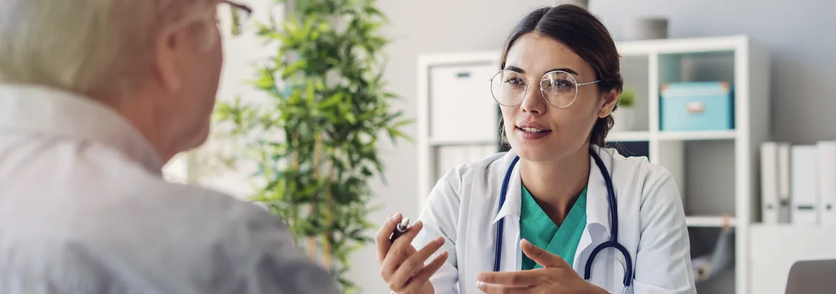 Female doctor sitting with male patient in a discussion.