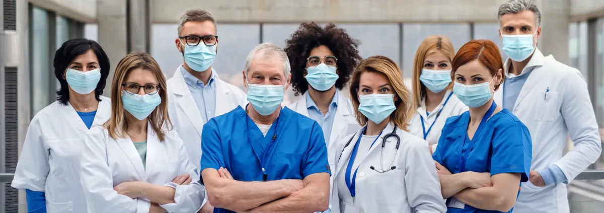 Group of doctors with face masks looking at camera.