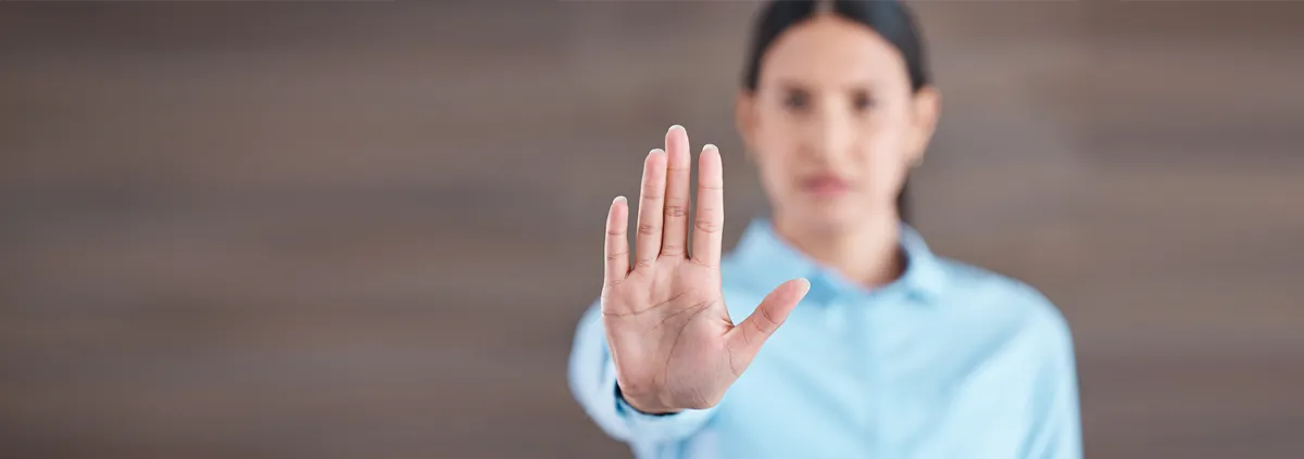 Woman holding up her hands making the stop/wait hand signal 