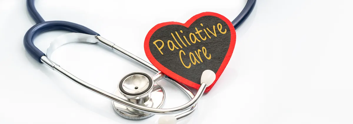 Image of a wooden shaped heart with the words  'Palliative Care' written on it next to a stethoscope.