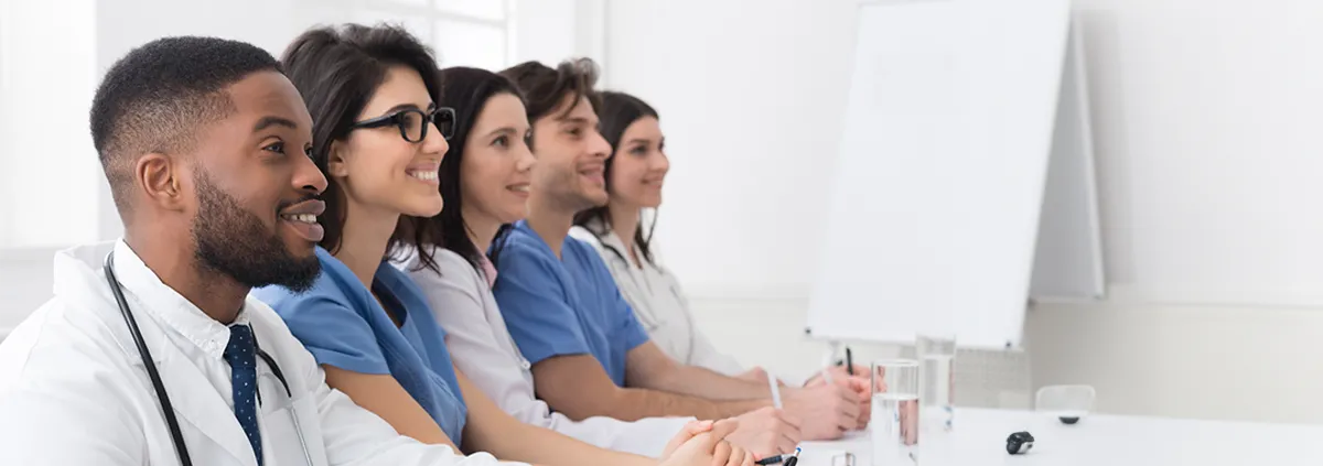 Group of health care providers sitting in a room during a presentation.