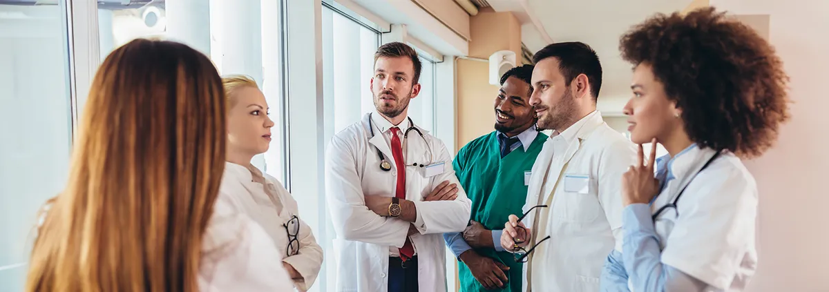 Health care providers talking in the hallway of a health care facility.